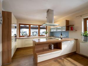una cocina con armarios blancos y una isla de madera en Haus Alpenrose, en Waidring