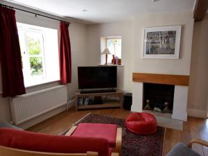 sala de estar con sofá rojo y chimenea en 5 Bed in Corfe Castle DC061, en Corfe Castle