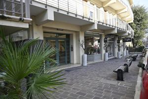 a building with benches in front of a store at Purpo in Cattolica