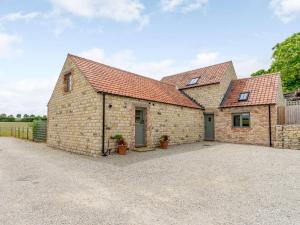 an exterior view of a brick barn with a driveway at 3 Bed in Malton 75899 in Amotherby