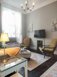 a living room with a couch and a tv at Beautiful Georgian New Town 2 bed apartment in Edinburgh