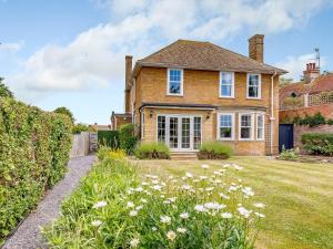 a brick house with a yard with flowers at 4 Bed in Bexhill on Sea 77602 in Bexhill