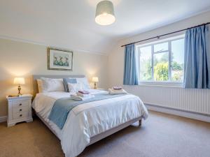una camera da letto con un letto con tende blu e una finestra di 3 Bed in Dawlish 72972 a Dawlish