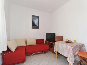 a living room with a red couch and a table at Apartments Lampion in Vir