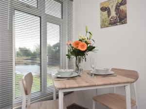 a dining room table with a vase of flowers on it at 1 Bed in Thetford 76493 in East Harling