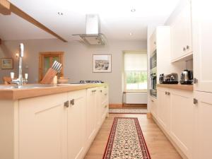 eine Küche mit weißen Schränken und einem Teppich auf dem Boden in der Unterkunft 2 Bed in St Andrews 75868 in Ladybank