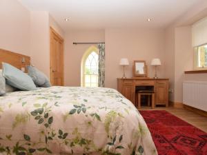 Schlafzimmer mit einem Bett, einem Schreibtisch und einem Fenster in der Unterkunft 2 Bed in St Andrews 75868 in Ladybank