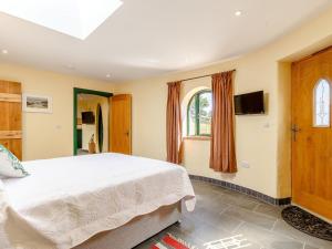 um quarto com uma cama e uma televisão na parede em 2 Bed in Westward Ho 77292 em Bideford