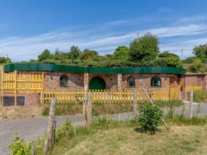 um edifício de tijolos com uma porta verde e uma cerca em 2 Bed in Westward Ho 77292 em Bideford