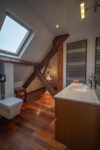 Un baño con lavabo, inodoro y ventana. en Villa Ellerslie, en Saint-Malo