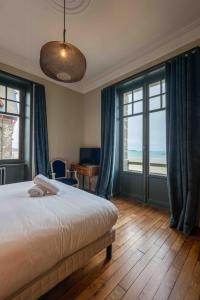 a bedroom with a bed and a view of the ocean at Villa Ellerslie in Saint Malo