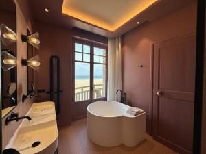 a bathroom with a large tub and a window at Villa Ellerslie in Saint Malo