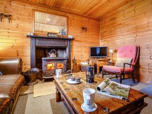 - un salon avec une cheminée, un canapé et une table dans l'établissement 1 bed property in Strath CA044, à Gairloch