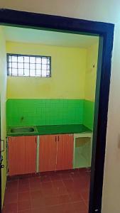 an empty kitchen with a sink and green tiles at Holiday home in Ooty