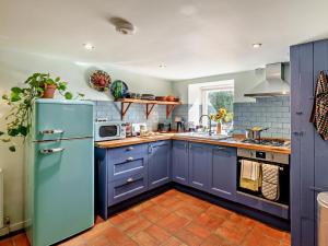 uma cozinha com armários azuis e um frigorífico azul em 1 Bed in Robin Hoods Bay G0191 em Fylingdales