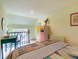 a bedroom with a bed and a table and a refrigerator at 1 Bed in Robin Hoods Bay G0191 in Fylingdales