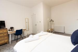 um quarto branco com uma secretária e uma cama em Suite 2 - Comfy Spot in Oldham Sociable House em Oldham