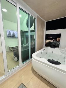 a large white bath tub in a room with a large window at Sugar Beach Bangsaen in Ban Bang Saen (1) +17 photos