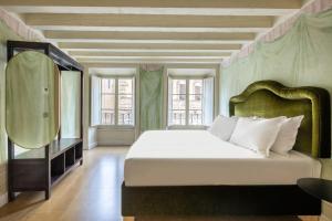 una camera con un grande letto e uno specchio di numa I Felice Rooms & Apartments a Firenze