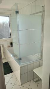 Appartment B 40 في بيرماسونس: دش زجاجي في حمام مع حوض استحمام