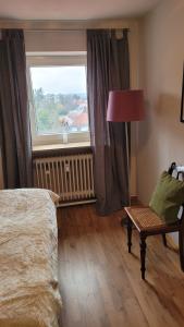 a bedroom with a window and a chair and a lamp at Appartment B 40 in Pirmasens