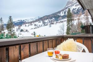 a table with two glasses of wine and bread on a balcony at Hotel Nigritella in Selva di Cadore