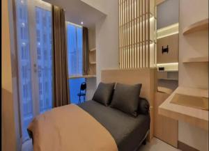 a bedroom with a bed and a large window at OYO 93501 Tokyo Riverside in Rawalembang