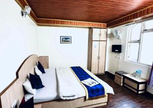 a bedroom with a bed in a room with a window at Dhe Kyi Khang by Magwave Hotels-100 Mts from MG Marg in Gangtok