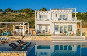 een huis met een zwembad ervoor bij Villa Avgi in Agios Nikolaos