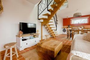 a living room with a tv and a staircase at Les Gîtes Warenne - 1 in Saint-Étienne-au-Mont