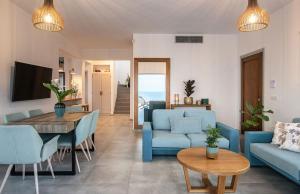 een woonkamer met blauwe banken en een tafel bij Villa Avgi in Agios Nikolaos