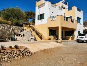 une maison avec une voiture garée devant elle dans l'établissement Το σπίτι που σε ταξιδεύει (The dream boat house)., à Agia Galini