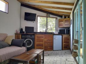 a living room with a couch and a kitchen at Ti Kaz Kafé - Charmante Case créole indépendante à St Leu in Saint-Leu