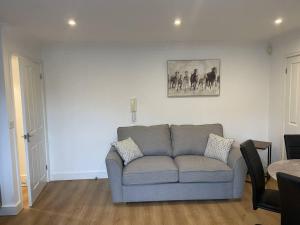 sala de estar con sofá y una foto en la pared en Modern The Mews Apartment en Bury Saint Edmunds