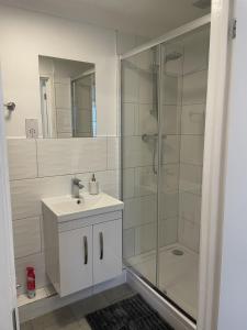 a bathroom with a glass shower and a sink at Modern The Mews Apartment in Bury Saint Edmunds