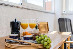 a table with two glasses of orange juice and grapes at Apartment Kristian in Cres