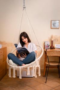 a woman sitting in a swing reading a book to a baby at Il Fiorile in Borghetto Di Borbera