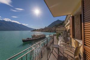 a balcony with a boat in the water at Hotel all'Azzurro in Limone sul Garda