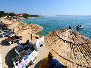 a group of beach chairs and umbrellas on a beach at Apartments Lampion in Vir