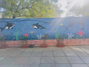 a mural of whales and fish on a wall at Mangal Residency Rooftop Pool in Udaipur