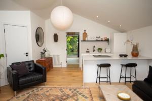 a living room with a couch and a kitchen at Chorlton Stylish Studio & Roof Terrace Apartments in Manchester