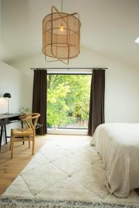a bedroom with a bed and a desk and a window at Chorlton Stylish Studio & Roof Terrace Apartments in Manchester