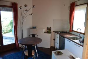 a small kitchen with a table and a sink at Chalet, quiet, with view and pool (at summertime) in Ventenac-Cabardès