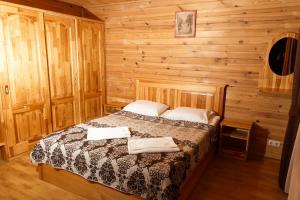 Un dormitorio con una cama en una cabaña de madera. en Bereg holiday park, en Svetlogorskoye 124 fotos más