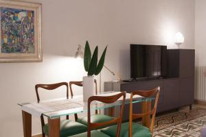comedor con mesa, sillas y TV en Amore Se Luxury Apartment en Corato