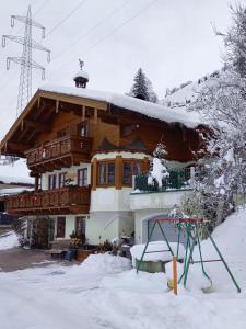 a large wooden house with snow on the roof at Vorderkreuzsaalgut Rettenwender Gertraud in Wagrain