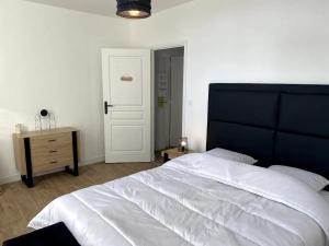 1 dormitorio con 1 cama blanca grande y cabecero negro en Cocooning 1 Conciergerie Leroy en Boulogne-sur-Mer