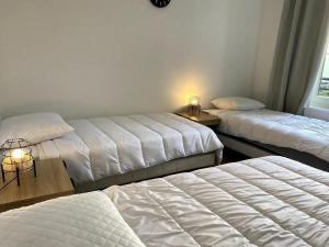 3 camas en una habitación con sábanas blancas en Cocooning 1 Conciergerie Leroy en Boulogne-sur-Mer