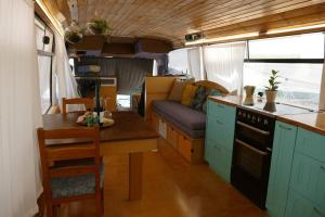 a kitchen with a table and a couch in an rv at MashikaBus משיקה בס אירוח מפנק על גלגלים in Ta‘oz