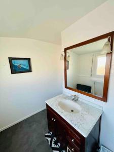 a bathroom with a sink and a mirror at La Maison du Temps Retrouvé à Wissant in Wissant